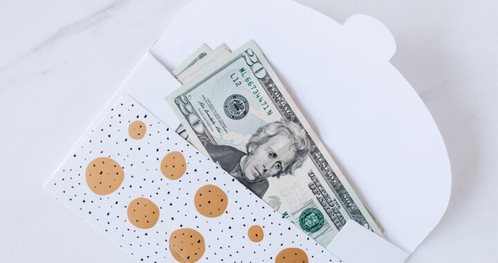 An envelope with decorative design containing dollar bills partially visible