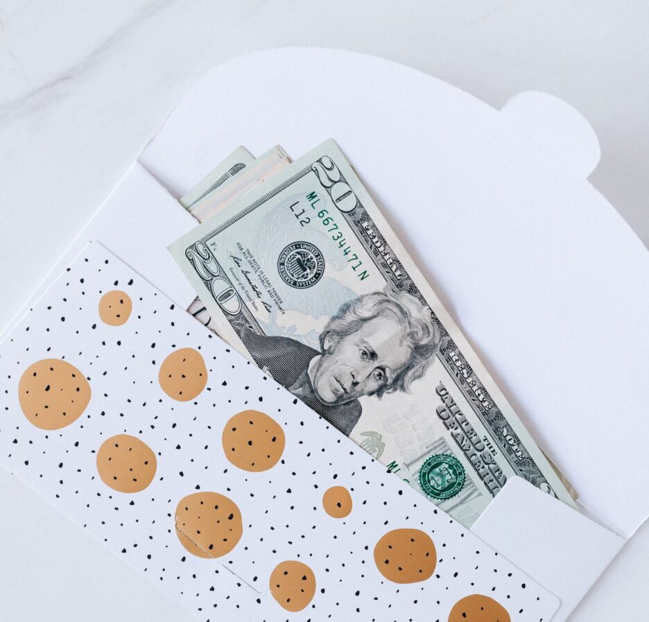 An envelope with decorative design containing dollar bills partially visible