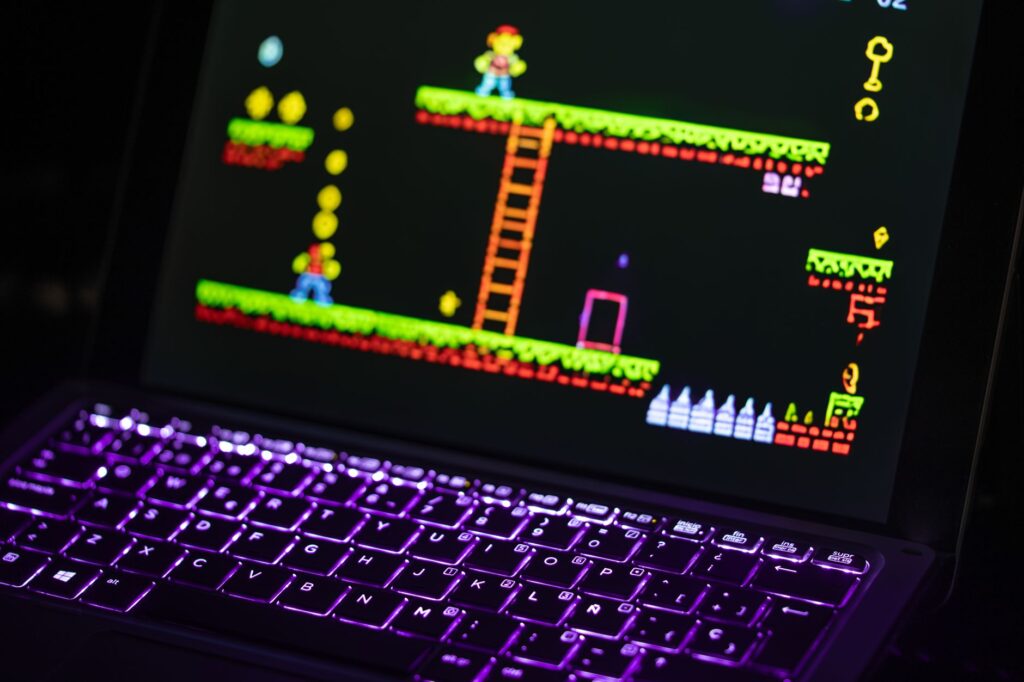 Close-up of a keyboard in front of a colorful retro video game screen