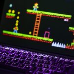 Close-up of a keyboard in front of a colorful retro video game screen