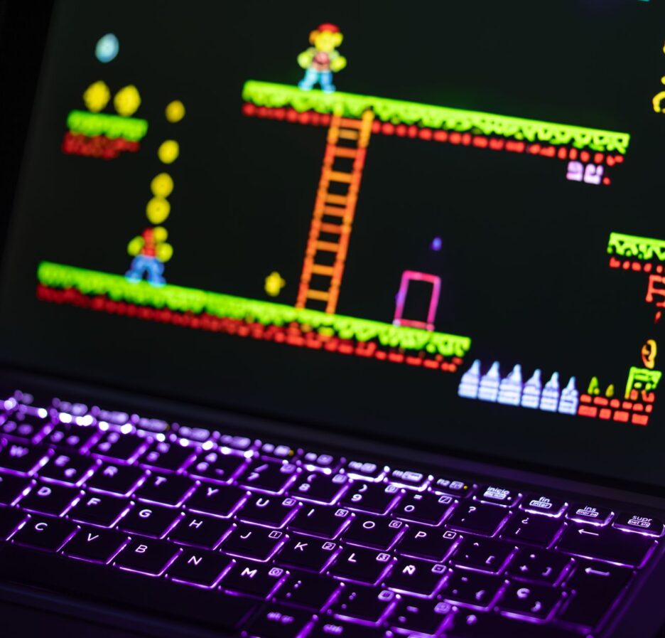 Close-up of a keyboard in front of a colorful retro video game screen